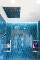 Shower niches in blue tile bathroom of custom home